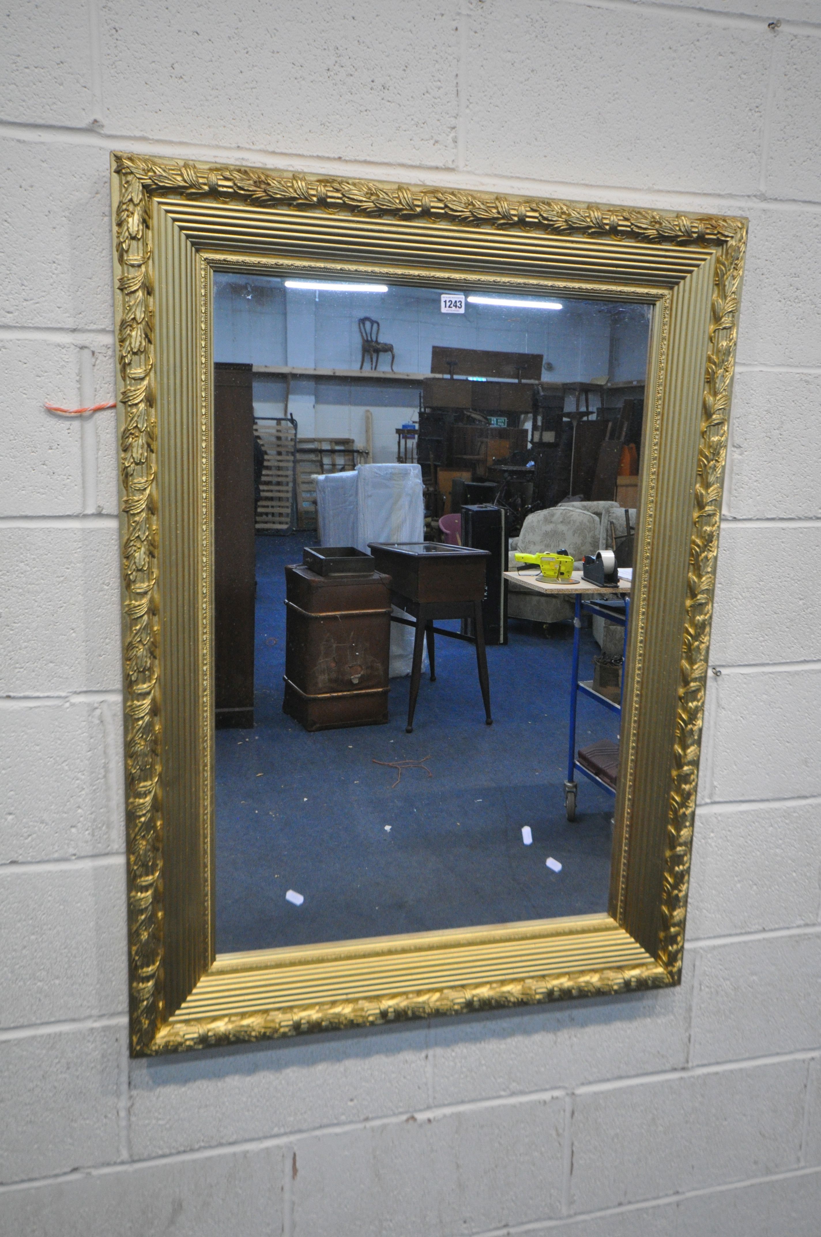 A LARGE RECTANGULAR GILT FRAME WALL MIRROR, with foliate detail, 104cm x 84cm (good condition)