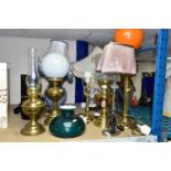 EIGHT TABLE LAMPS, SHADES AND CHIMNEYS, comprising a brass based oil lamp, three electric lamps in