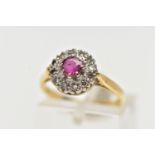 AN 18CT GOLD RUBY AND DIAMOND CLUSTER RING, centering on a circular cut ruby, in an eight claw