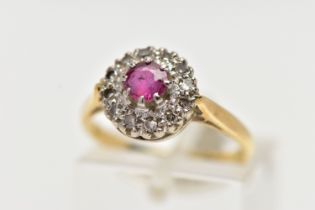 AN 18CT GOLD RUBY AND DIAMOND CLUSTER RING, centering on a circular cut ruby, in an eight claw