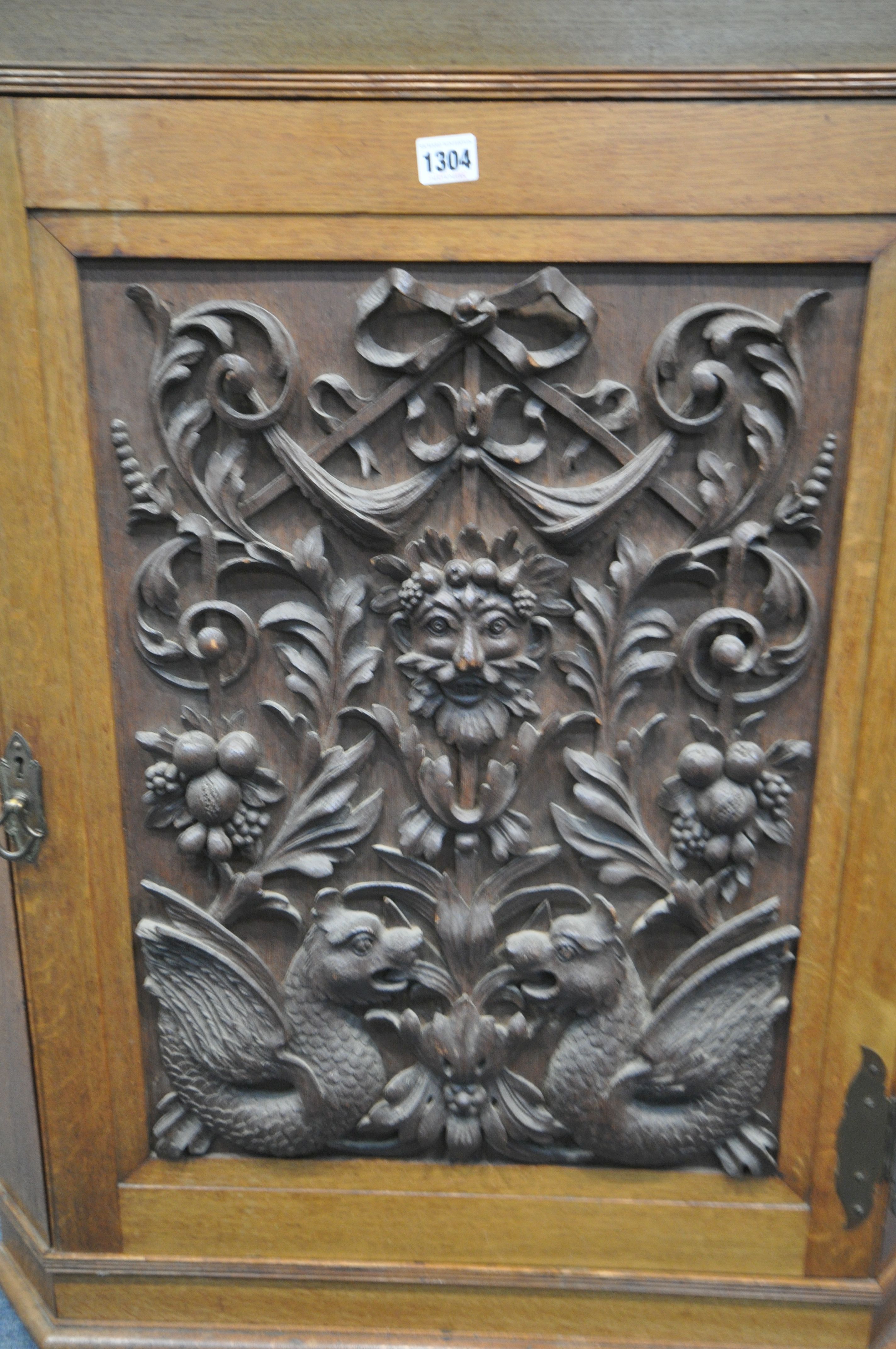A 20TH CENTURY OAK HANDING CORNER CUPBOARD, with a heavily carved foliate panel, a depicting a - Image 3 of 4