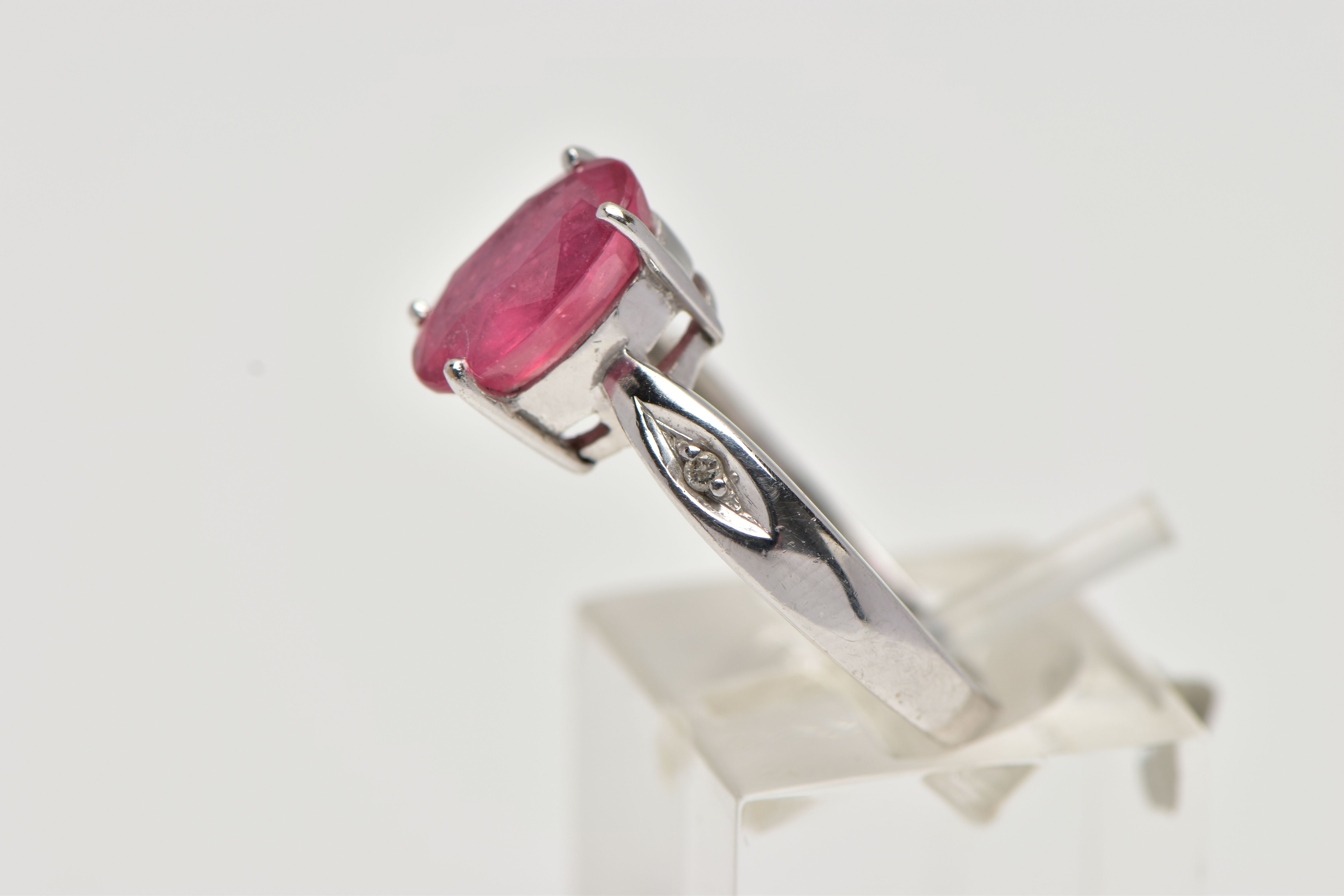 AN 18CT WHITE GOLD RING, centrally set with an oval cut orange/red colour corundum, flanked with two - Image 2 of 4