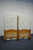 A PAIR OF REST ASSURED SINGLE MATTRESSES, with pine bed frames (condition - discolouration to bed