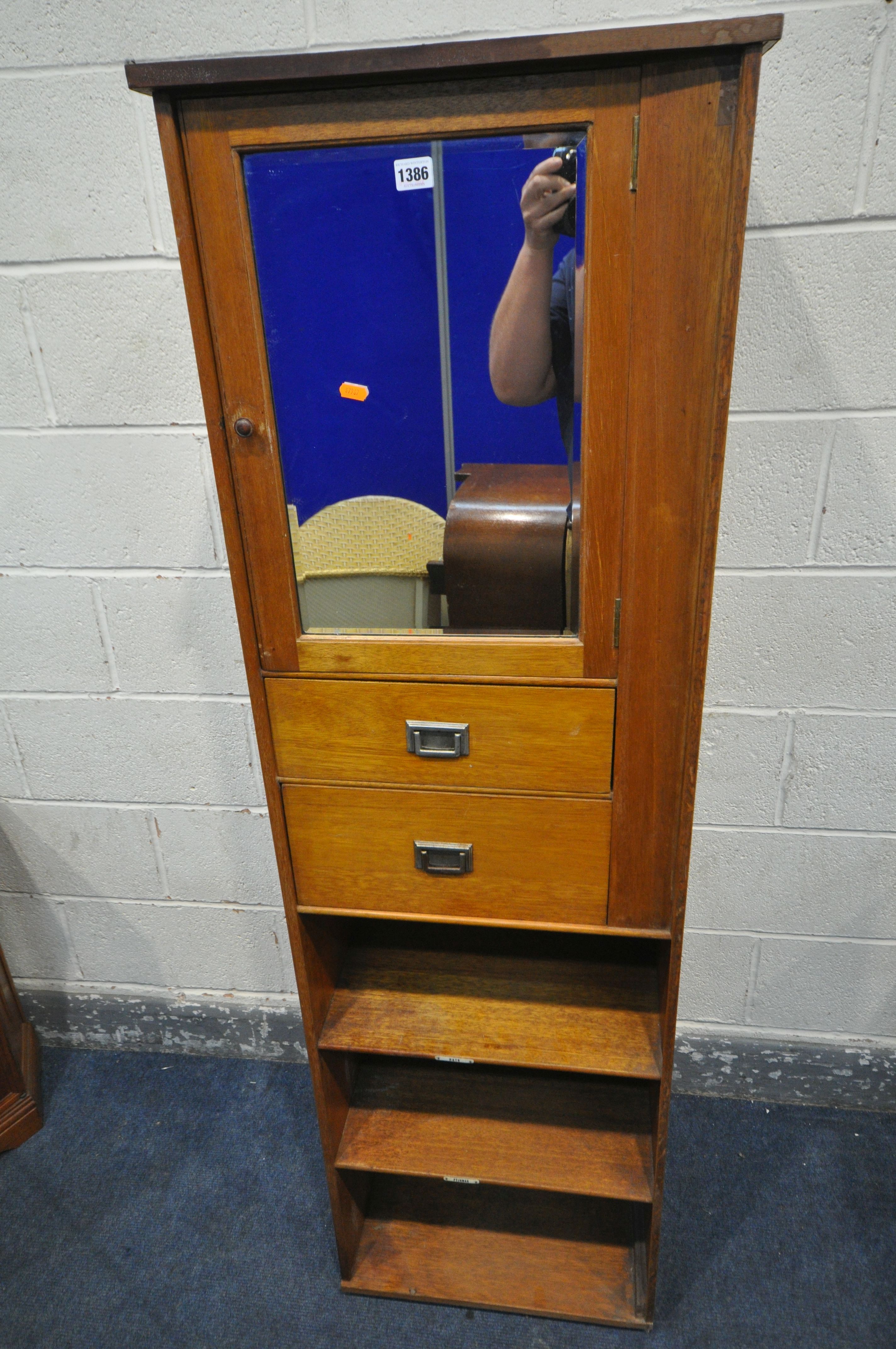 A 20TH CENTURY OAK CABINET, with a single bevelled mirror door, above two drawers and two shelves,