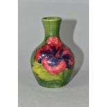 A MOORCROFT POTTERY HIBISCUS PATTERN BUD VASE, of baluster form, with tube lined yellow, pink and