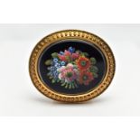 A VICTORIAN MICRO MOSAIC BROOCH, of an oval form, centering on an onyx oval inlay decorated with a