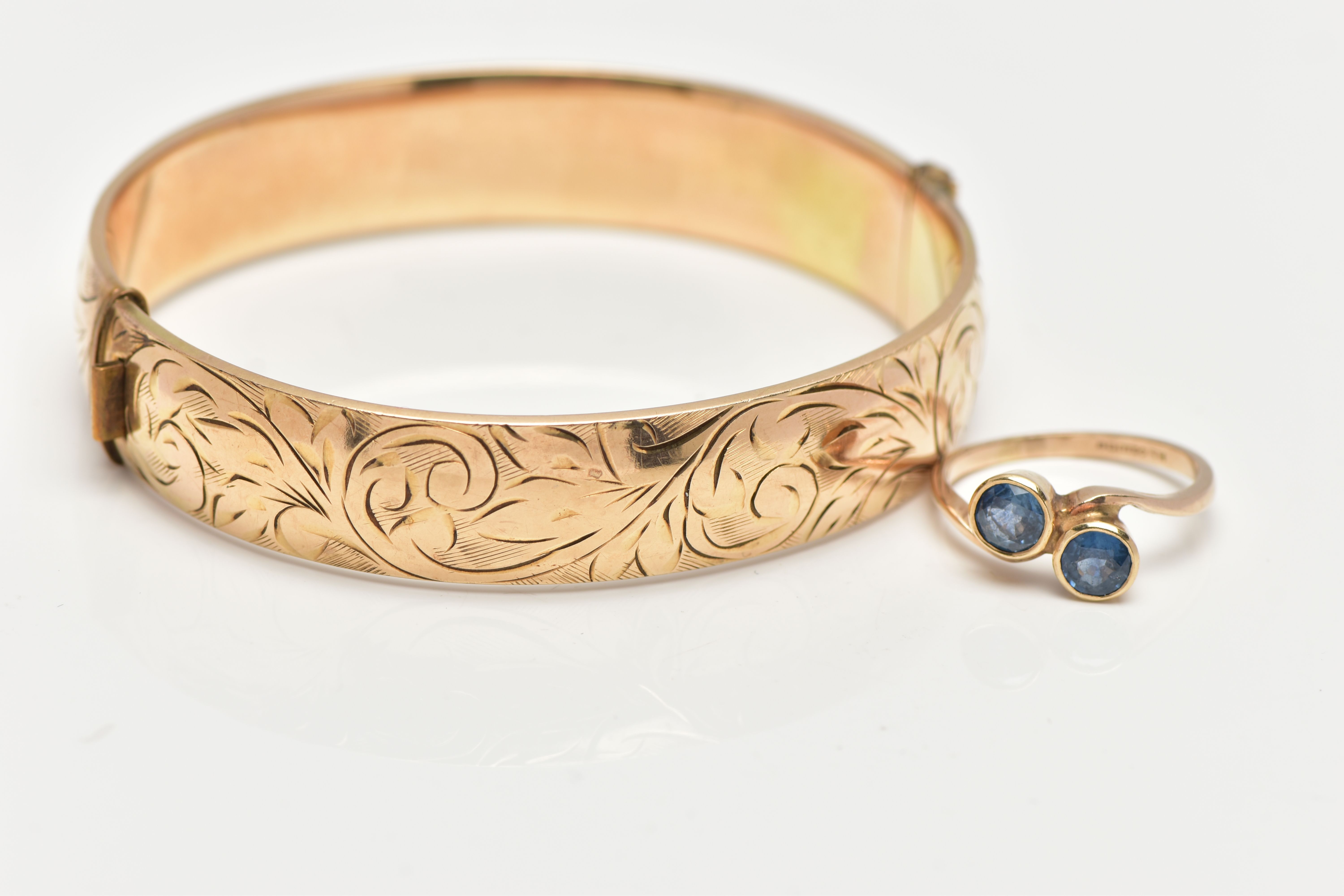 A 9CT GOLD SAPPHIRE RING AND A GOLD PLATED HINGED BANGLE, the ring of a cross over design, set