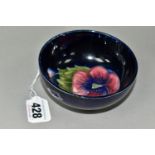 A SMALL MOORCROFT POTTERY FOOTED BOWL, in Blue Pansy pattern, with a tube lined red and purple pansy