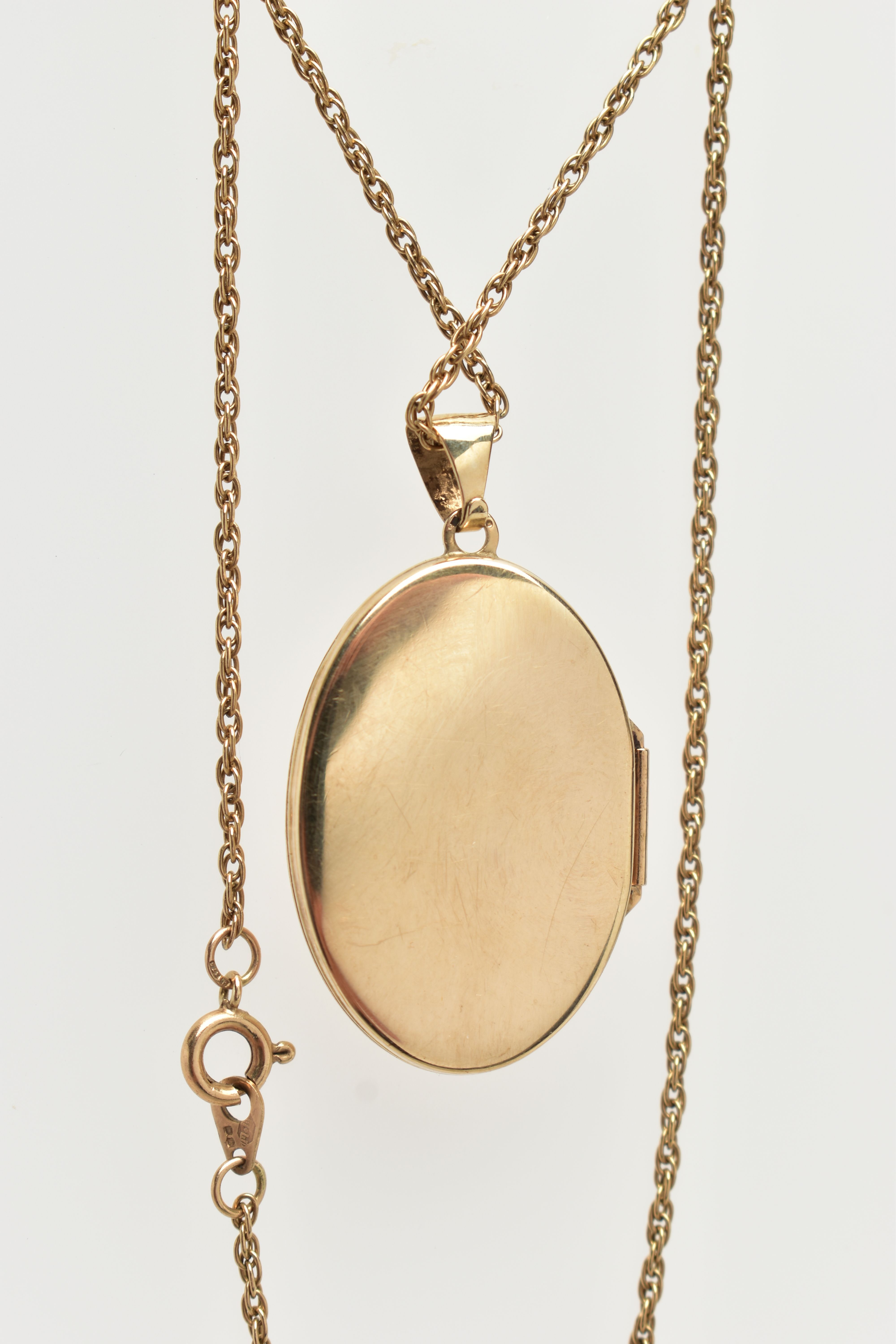 A 9CT GOLD LOCKET AND CHAIN, the locket of an oval form, decorated with a foliate pattern and vacant - Image 2 of 3