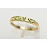 A 9CT GOLD PERIDOT RING, designed with a row of five bar set, square cut peridots, to a polished