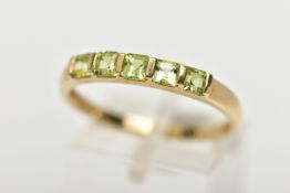 A 9CT GOLD PERIDOT RING, designed with a row of five bar set, square cut peridots, to a polished