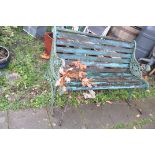 A WOODEN SLATTED GARDEN BENCH cast iron ends contain pierced foliate detailing 128cm wide (Condition