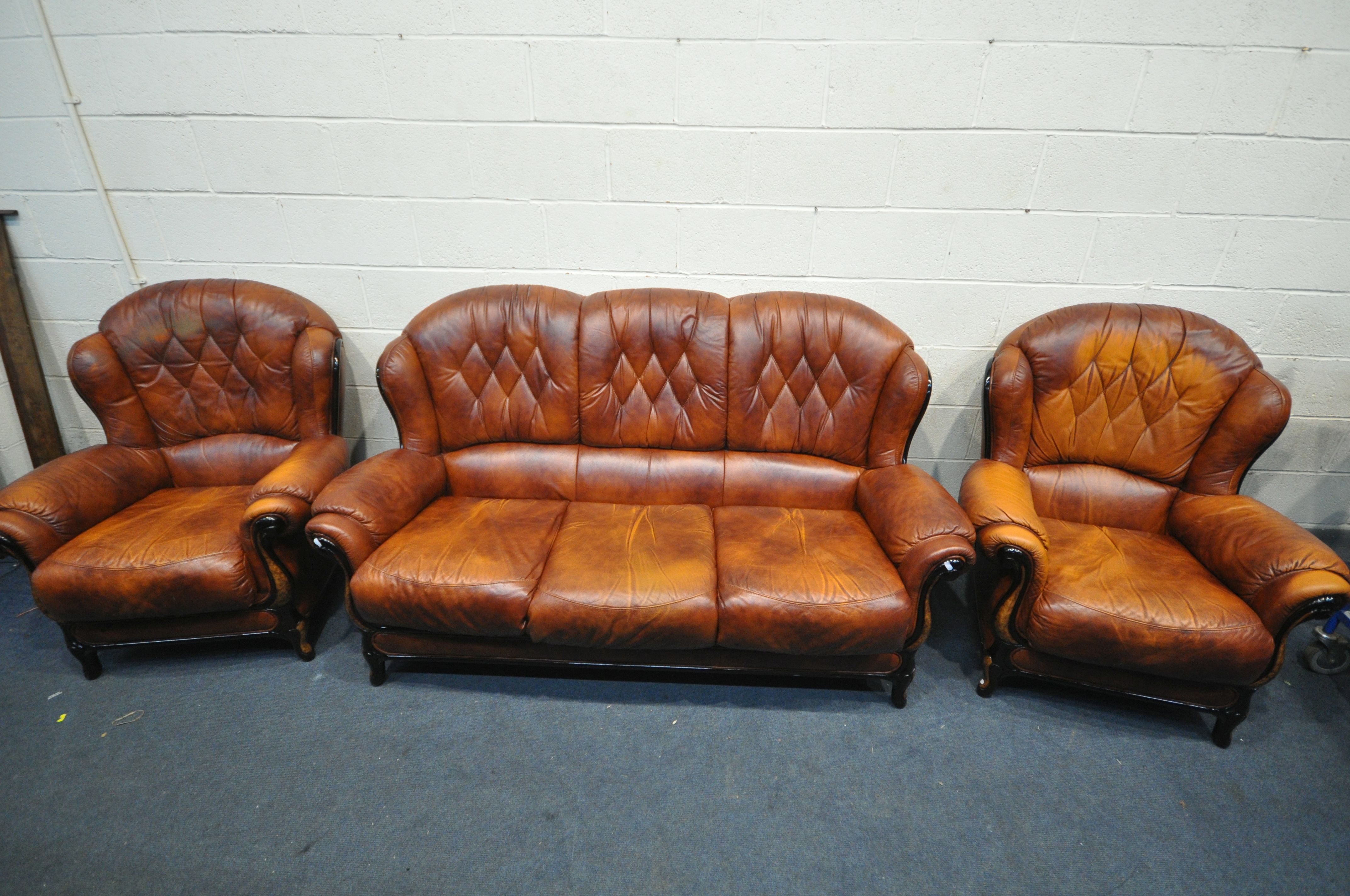 A BROWN LEATHER THREE PIECE LOUNGE SUITE, comprising a three seater sofa and a pair of armchairs (