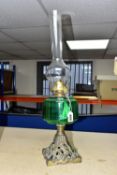 A VICTORIAN OIL LAMP, with a green glass reservoir, cast foliate base and a Diamond Brand clear