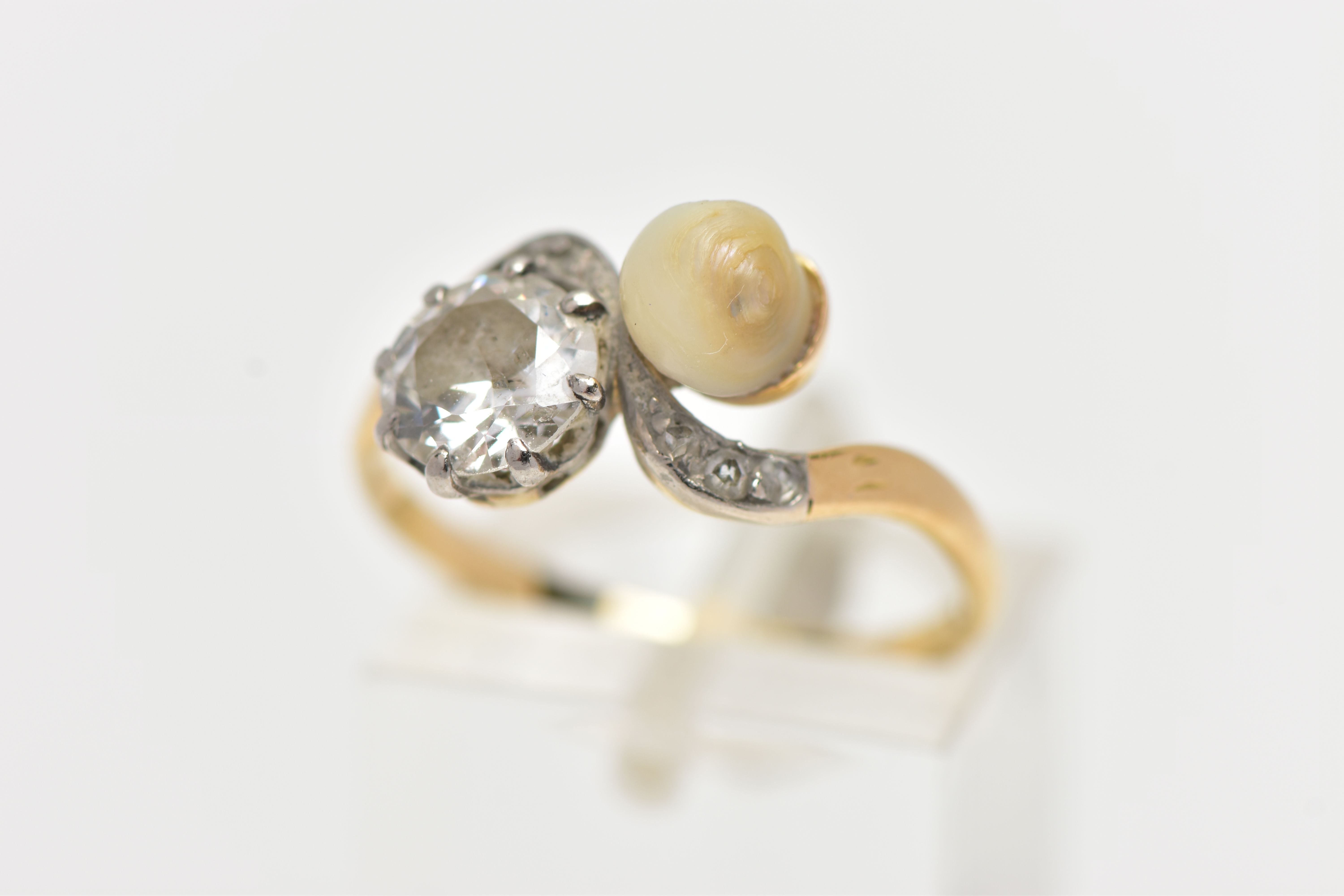 AN EARLY 20TH CENTURY 18CT GOLD DIAMOND AND PEARL DRESS RING, of crossover design, set with an early