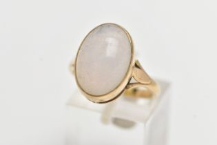 A YELLOW METAL CABOCHON RING, oval cabochon assessed as chalcedony, collet set within a yellow metal