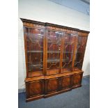 A REPRODUX STYLE MAHOGANY BREAKFRONT FOUR DOOR GLAZED BOOKCASE, enclosing adjustable glass