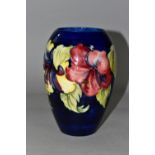 A MOORCROFT POTTERY VASE, of baluster form with a mauve and yellow Hibiscus pattern on a blue