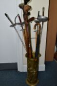 A STICK STAND CONTAINING FENCING FOILS, VINTAGE GOLF CLUBS AND ICE PICKS, the brass stick stand
