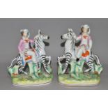 A PAIR OF STAFFORDSHIRE ZEBRAS, each being ridden in a naturalistic landscape, height