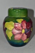 A MOORCROFT POTTERY GINGER JAR AND COVER, the green ground decorated in a red/purple clematis