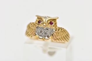 A YELLOW METAL GEM SET RING, in the form of an owl with spread wings, the body is set with single