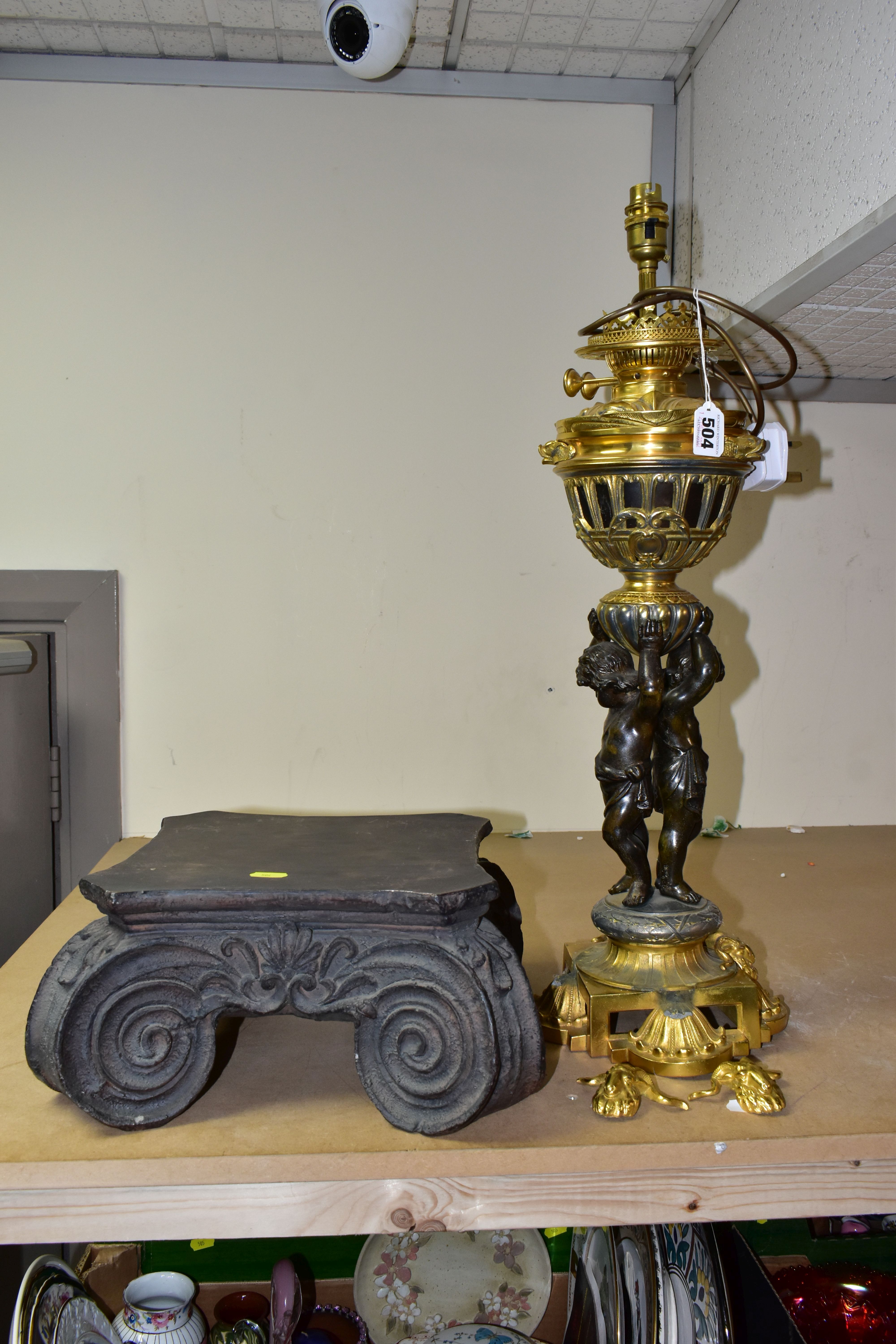 A DECORATIVE ELECTRIC TABLE LAMP IN THE FORM OF AN OIL LAMP, comprising a cast brass base, reservoir