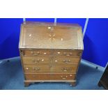 A GEORGIAN OAK FALL FRONT BUREAU, with a fitted interior, with four long graduated drawers, on