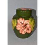 A MOORCROFT POTTERY GINGER JAR AND COVER, in the Coral Hibiscus pattern on a green ground, bears