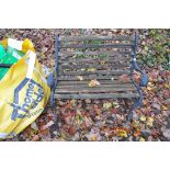 A MODERN SLATTED GARDEN BENCH WITH CAST IRON ENDS, detailed with lion head masks, width 95cm