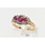 A 9CT YELLOW GOLD RUBY AND DIAMOND CLUSTER RING, designed with three graduated oval cut rubies to