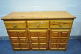 A MODERN PINE SIDEBOARD, with three drawers over three cupboard doors, length 142cm x depth 52cm x