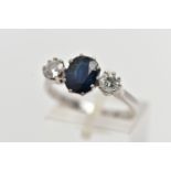 AN 18CT WHITE GOLD SAPPHIRE AND DIAMOND THREE STONE RING, centering on an oval cut deep blue