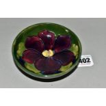 A SMALL MOORCROFT POTTERY 'CLEMATIS' FOOTED DISH, diameter 11.5cm, a mauve clematis decoration on