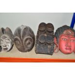FIVE TWENTIETH CENTURY WOODEN MASKS, four of African styles, the fifth in an Asian style (possibly