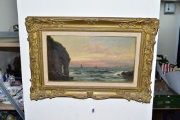GEORGE HENRY JENKINS (BRITISH 1843-1914) AN UNTITLED SUNSET MARITIME SEASCAPE, cliffs and rocks to