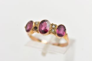 AN EARLY 20TH CENTURY 9CT GOLD GEM SET RING, designed with three oval cut graduated garnets,