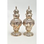 A PAIR OF SILVER PEPPERETTES, each of a baluster form, embossed floral pattern, on round bases,