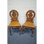 A PAIR OF OAK SHIELD BACK HALL CHAIRS (condition:-both chairs with cracks and repairs to the back,