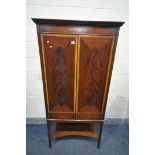 A MAHOGANY AND CROSSBANDED TWO DOOR DRINKS CABINET, with three glass shelves, light switch, brushing