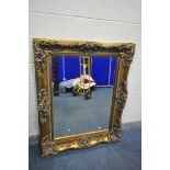 A LARGE RECTANGULAR GILT FRAMED BEVELLED EDGE WALL MIRROR, with foliate carving, 135cm x 107cm (