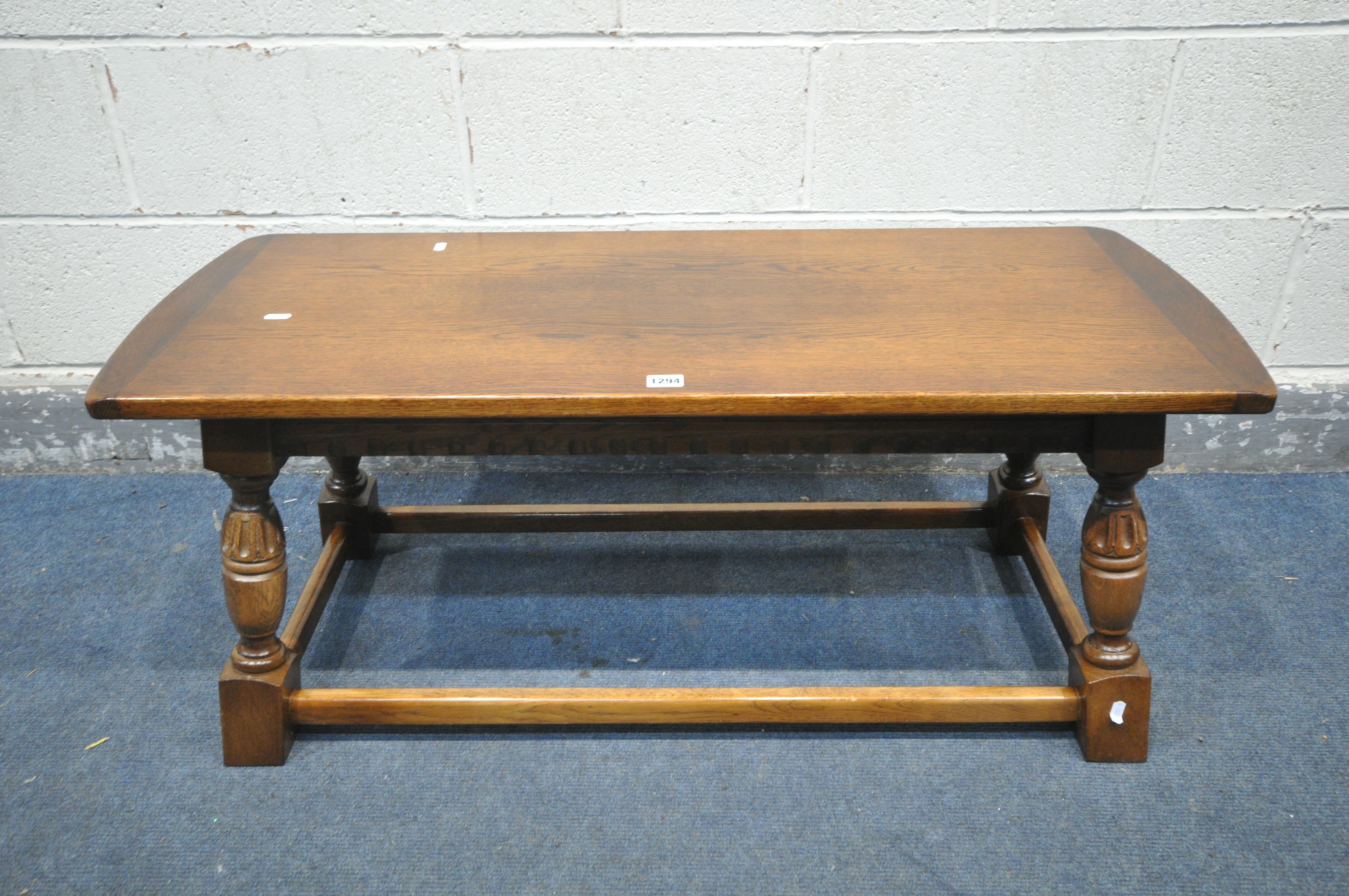 A 20TH CENTURY OAK COFFEE TABLE, on a shaped tapered support united by a box stretcher, length 106cm