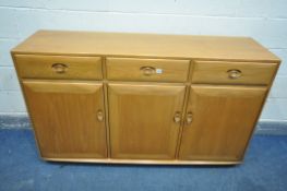 AN ERCOL BLOND SIDEBOARD, with three drawers over three cupboard doors, central drawer with