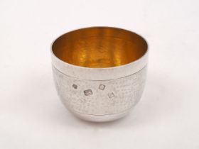 An Asprey & Co. silver tumbler cup, London, 1972, with hammered finish and gilded interior, designed
