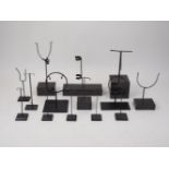 A collection of loose artefact stands of varying sizes and fittings, on plinths and glass bases,