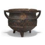 A Chinese iron cauldron form censer, 16th century, with two angular handles, the body decorated with