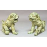 A pair of Chinese bronze temple lions, 20th century, one cast with a smaller temple lion by its
