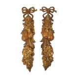 A pair of giltwood wall ornaments, second half 20th century, carved with ribbon-tied fruit and