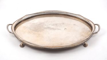 A large twin-handled tray with pierced sides, of oval form with shaped sides and four lion paw feet,