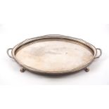 A large twin-handled tray with pierced sides, of oval form with shaped sides and four lion paw feet,